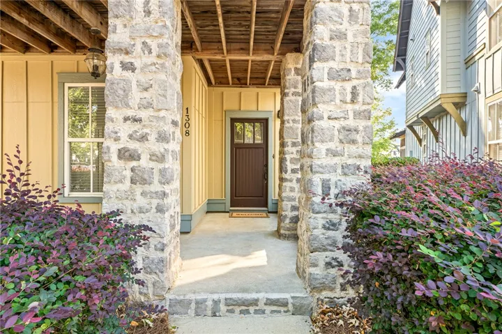 Stone pillars flank the welcoming entryway leading to a handsome craftsman-style front door.