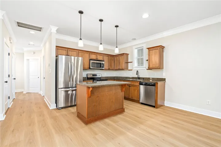 Warm wood cabinetry and granite countertops anchor this kitchen alongside a central island.