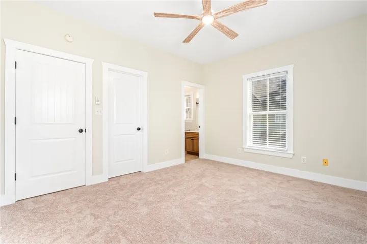Soft carpeting pairs with classic trim in this peaceful primary suite.
