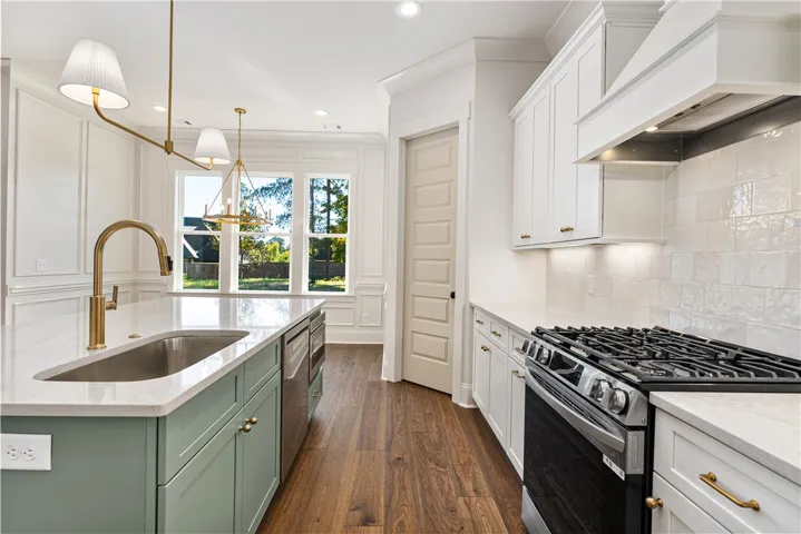 Gleaming hardwood floors and classic wainscoting complement a gourmet kitchen with custom cabinetry.