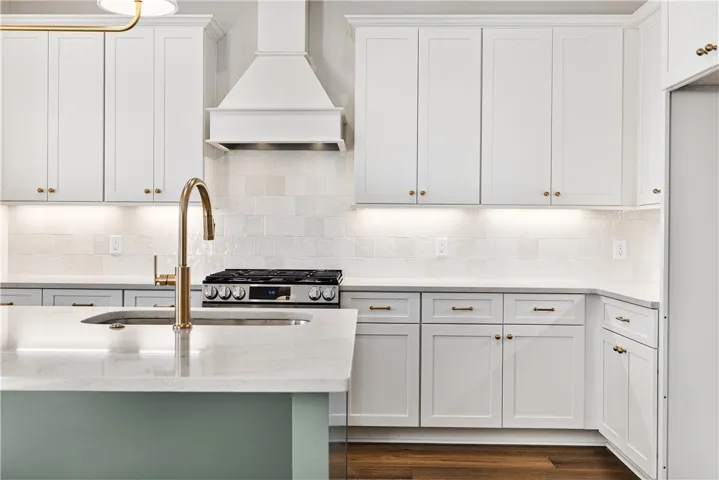 Rich hardwood flooring anchors the crisp shaker cabinetry and refined stone countertops in this space.
