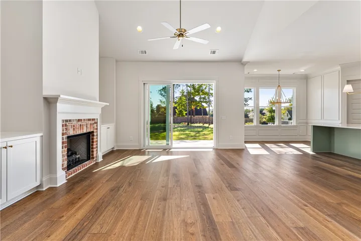 Gleaming hardwood floors and a brick fireplace anchor this bright, airy open concept living space.