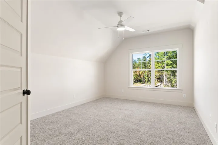 Slanted ceilings and plush carpeting define this tranquil upper-level bedroom.