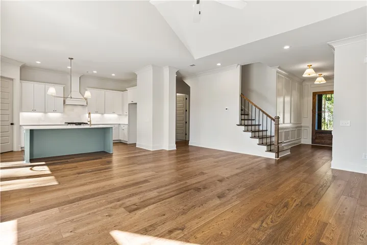 Rich hardwood flooring anchors the open concept living space and transitions to the kitchen.