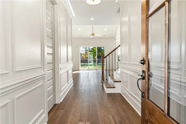 Rich hardwood floors and elegant wall molding welcome guests into a bright, airy entryway.
