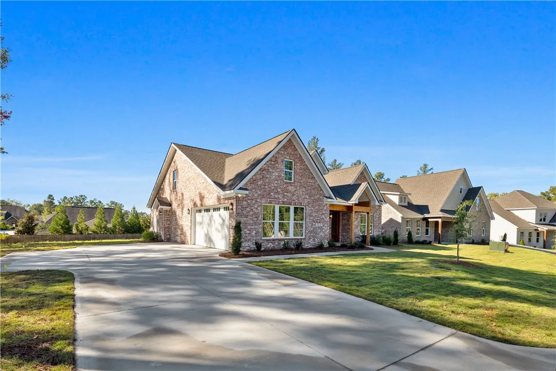 Timeless brick architecture and a spacious paved driveway create exceptional curb appeal.