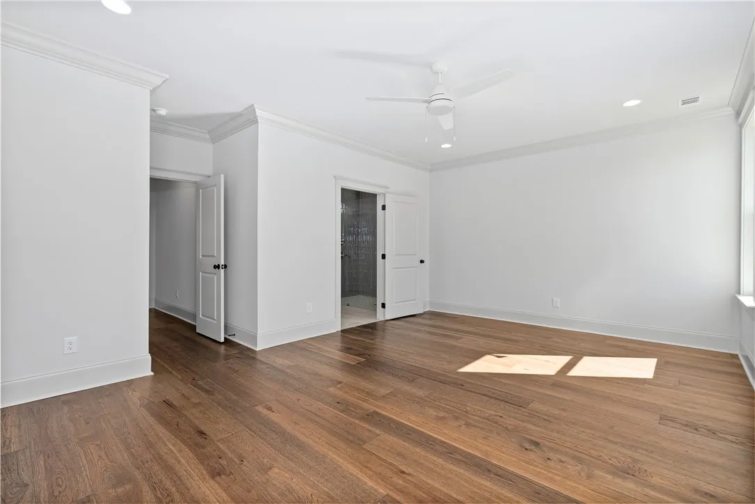 Rich hardwood flooring and classic crown molding define this clean-lined bedroom suite.