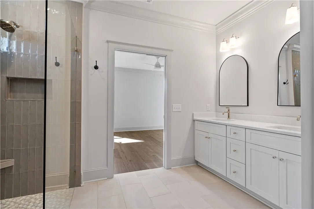 A spacious double vanity and a glass-enclosed walk-in shower elevate this primary bathroom design.