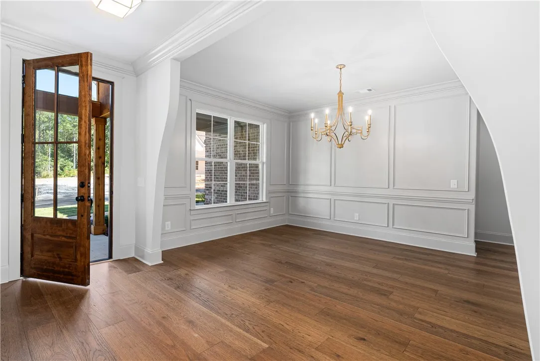 Gleaming hardwood floors and classic wainscoting define this elegant dining room near the entrance.