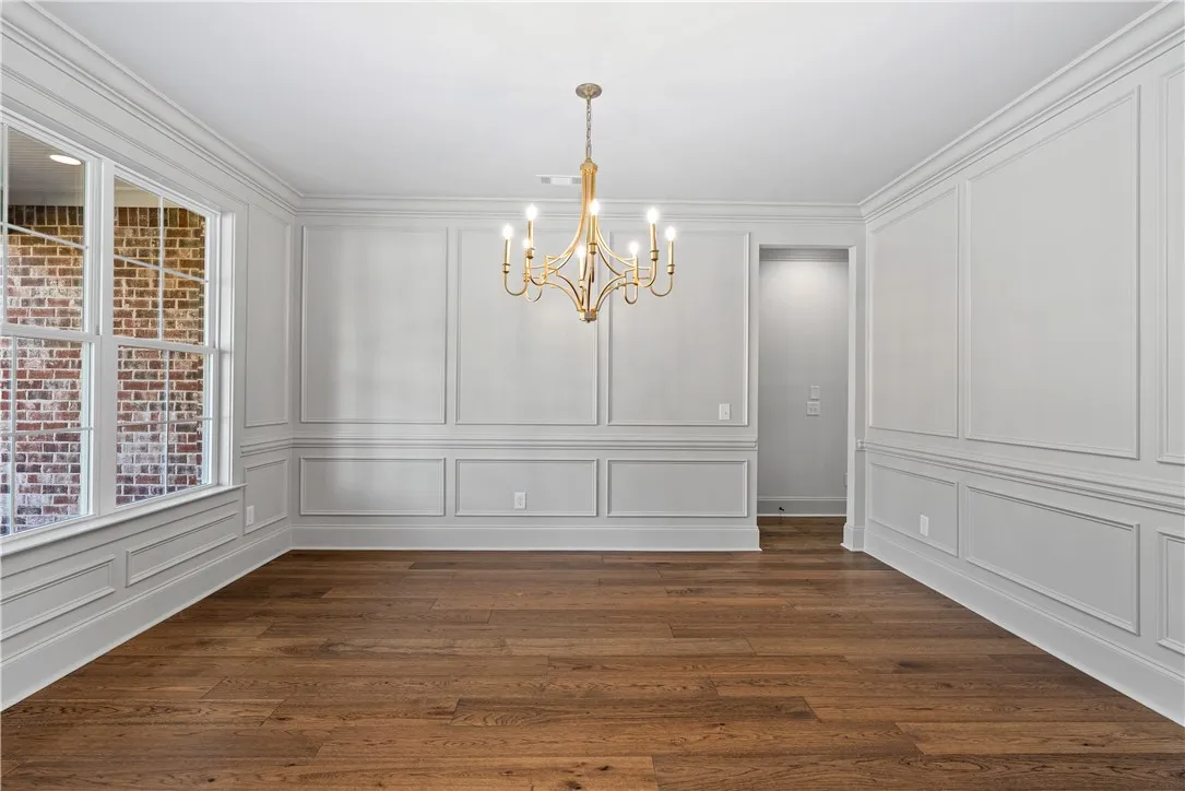 Elegant crown molding, classic wainscoting, and rich hardwood floors define this formal space.