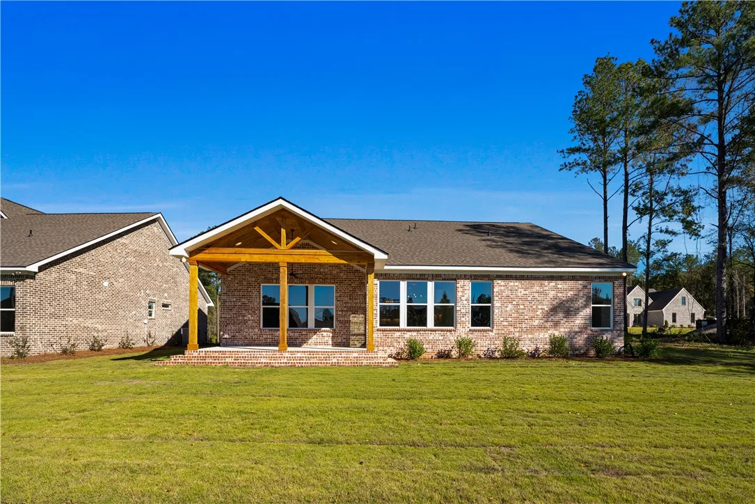 An inviting covered patio highlights the rear exterior of this brick home.