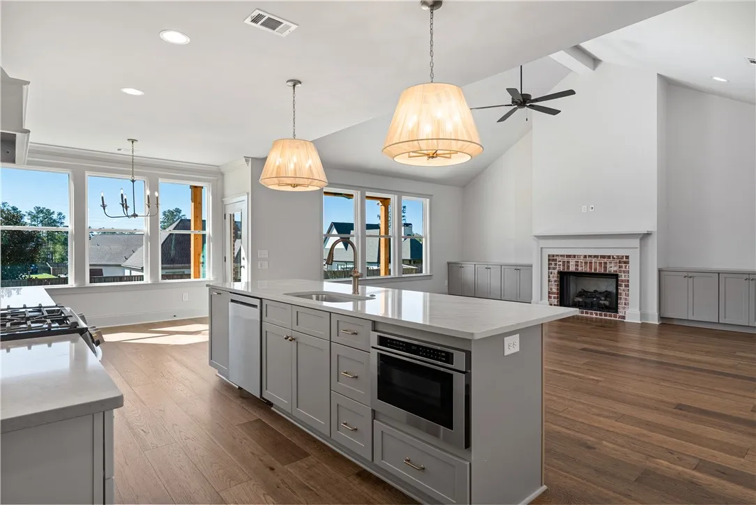 An airy open-concept layout connects a gourmet kitchen island directly to the fireplace-centered living area.