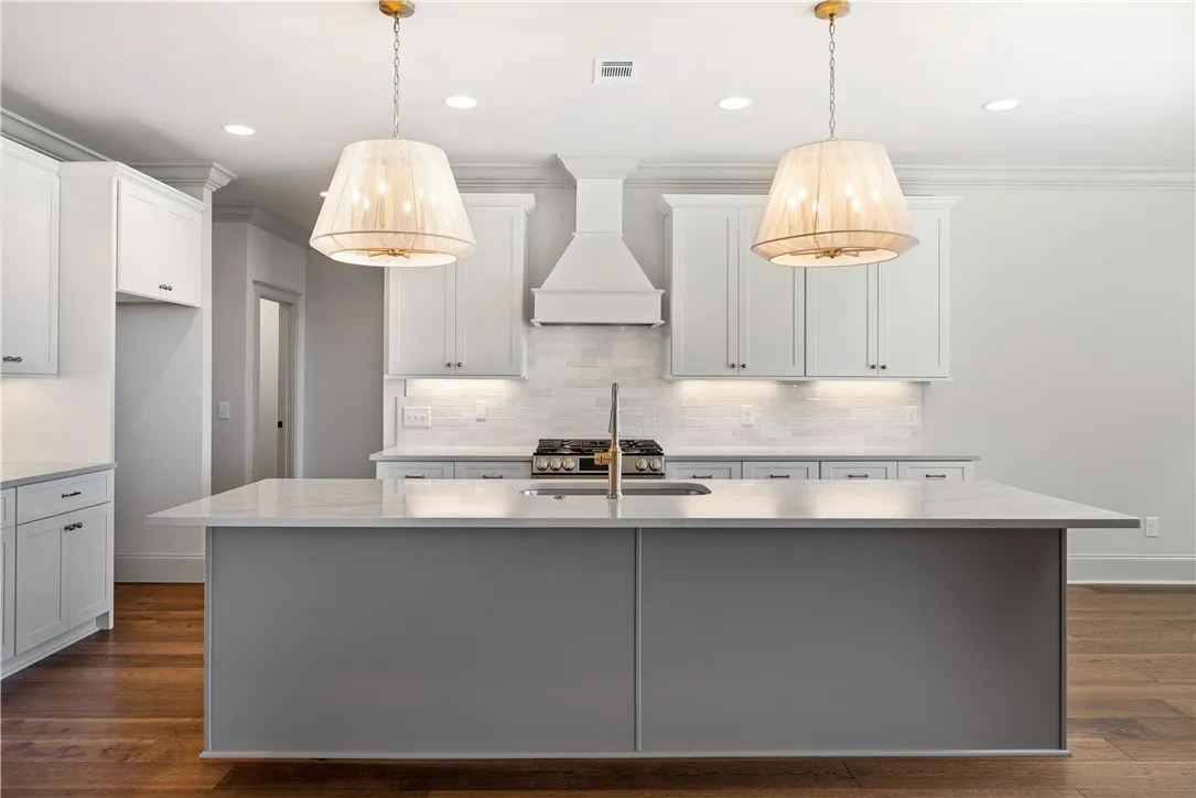 Rich hardwood flooring anchors the gourmet kitchen centered around a spacious prep island.