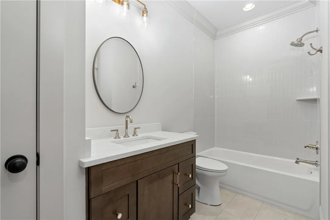 Clean lines and a modern vanity define this pristine full bathroom.