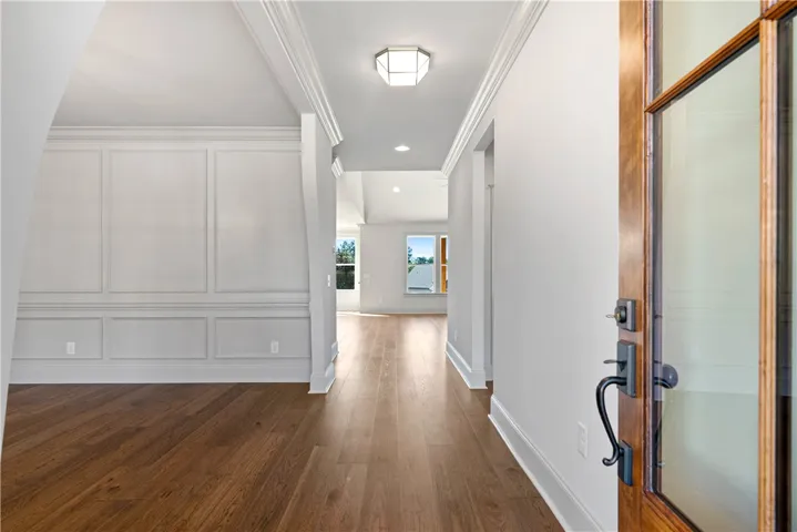 Rich hardwood floors and elegant wall paneling welcome guests into a bright, open floorplan.