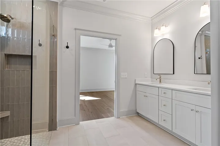A spacious double vanity and a glass-enclosed walk-in shower elevate this primary bathroom design.