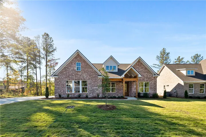 Classic brick architecture and neat gables create an inviting first impression under clear blue skies.