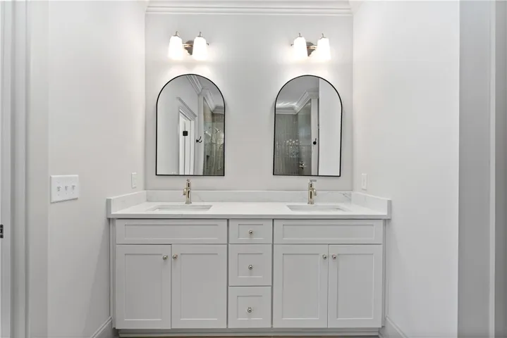Crisp trimwork and a stone-topped double vanity ground this elegant bathroom nook.