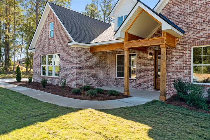 Rich brickwork pairs with natural wood columns defining this welcoming front entrance.