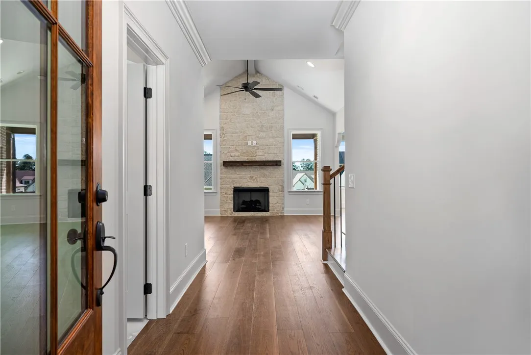 An inviting entry hallway flows directly into a living area featuring a stone fireplace.