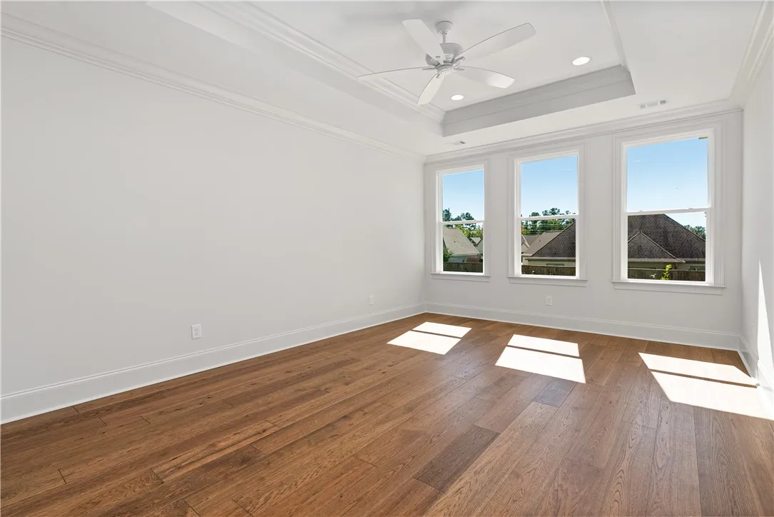 Rich hardwood floors and elegant crown molding define this versatile, light-filled interior space.