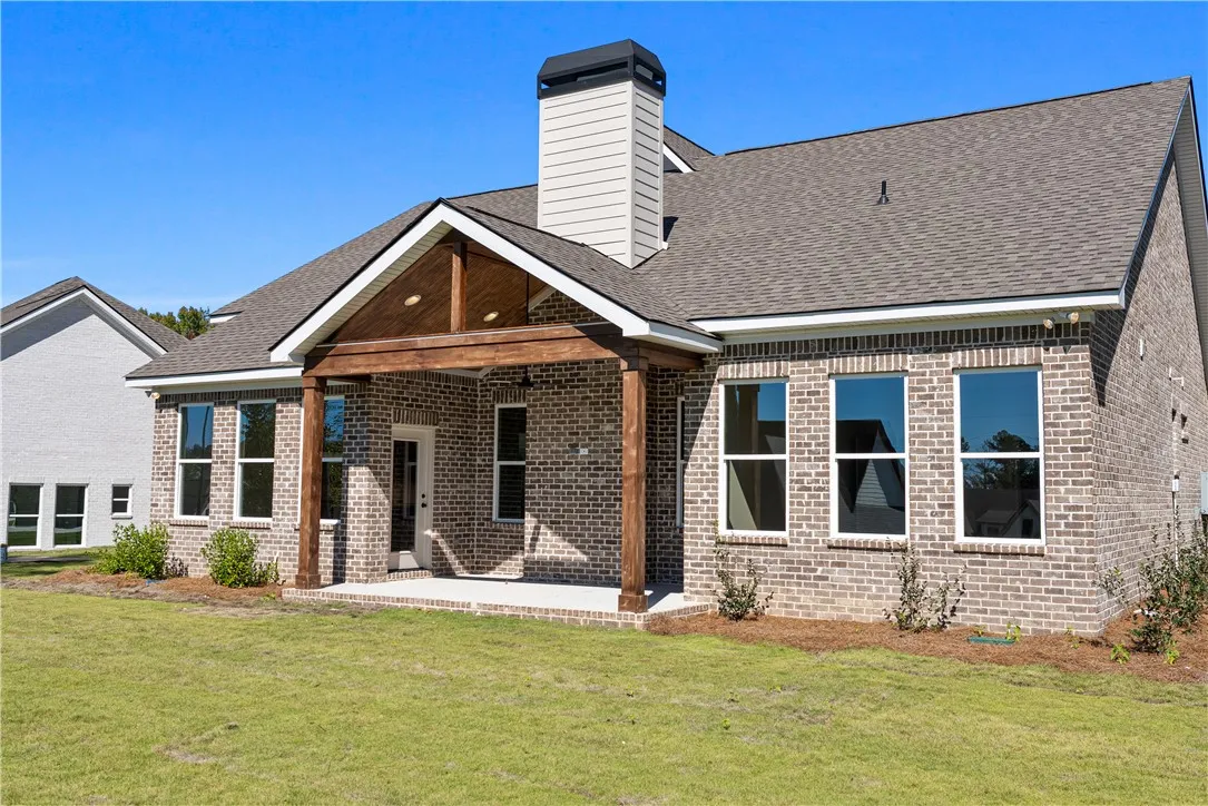 Rich brick masonry and a covered timber porch define this inviting backyard space.