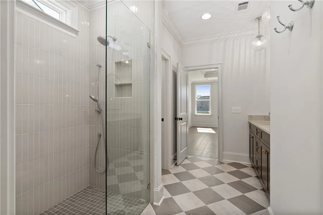 Crisp white tiled shower and checkerboard flooring define this pristine modern bathroom.