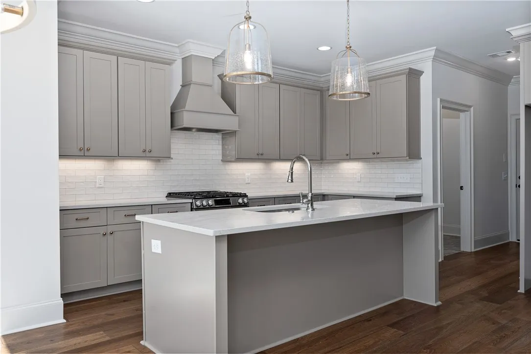 Rich hardwood flooring anchors the gourmet kitchen detailed with stone counters and crown molding.
