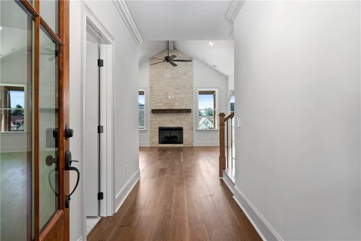 An inviting entry hallway flows directly into a living area featuring a stone fireplace.