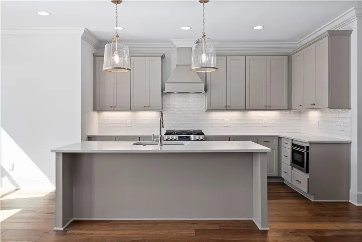 Fine craftsmanship shines through the classic cabinetry, subway tile backsplash, and warm hardwood flooring.