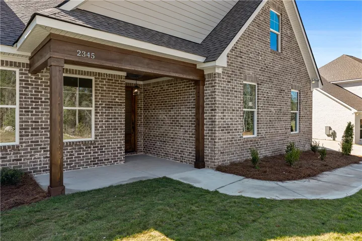 Rich brick masonry meets heavy timber posts on this welcoming covered front porch entry.