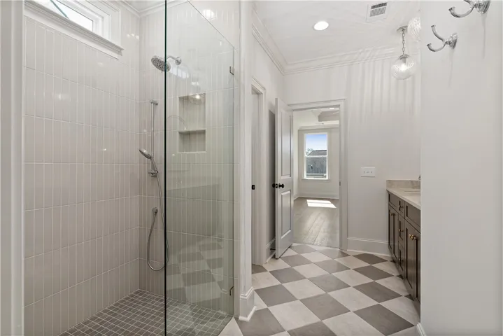 Crisp white tiled shower and checkerboard flooring define this pristine modern bathroom.