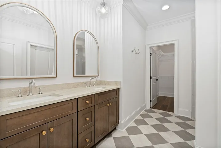 A refined vanity area showcases classic checkered flooring and elegant arched mirrors.