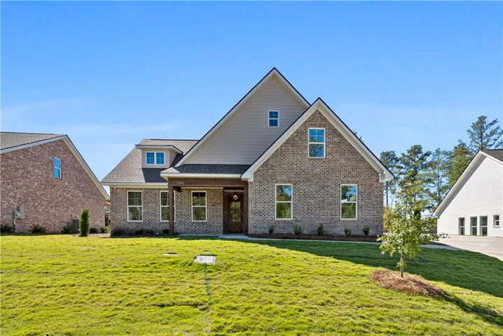 A classic brick exterior and gabled rooflines create timeless curb appeal on a manicured lawn.