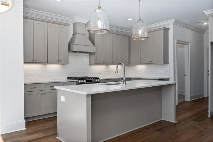 Rich hardwood flooring anchors the gourmet kitchen detailed with stone counters and crown molding.