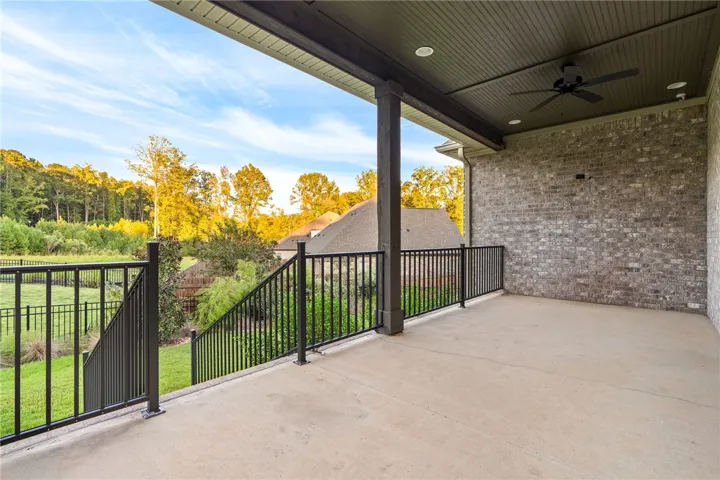 The rear façade is defined by an expansive covered porch and intentional landscape design.
