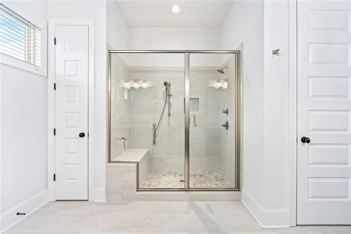 A transom window lends light to the primary bathroom.