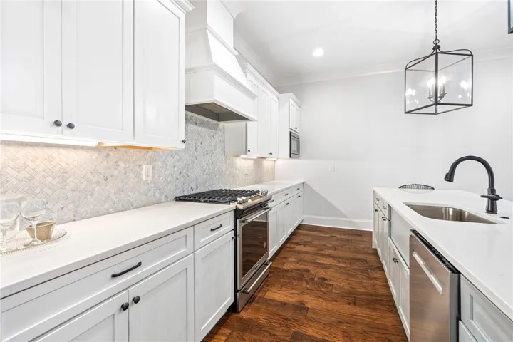 The kitchen's white cabinetry and countertops are balanced by the warm wood floors.