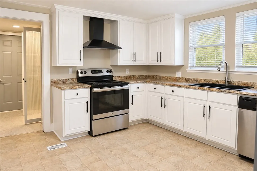 Rich stone counters and classic white cabinetry frame a classic and functional culinary space.