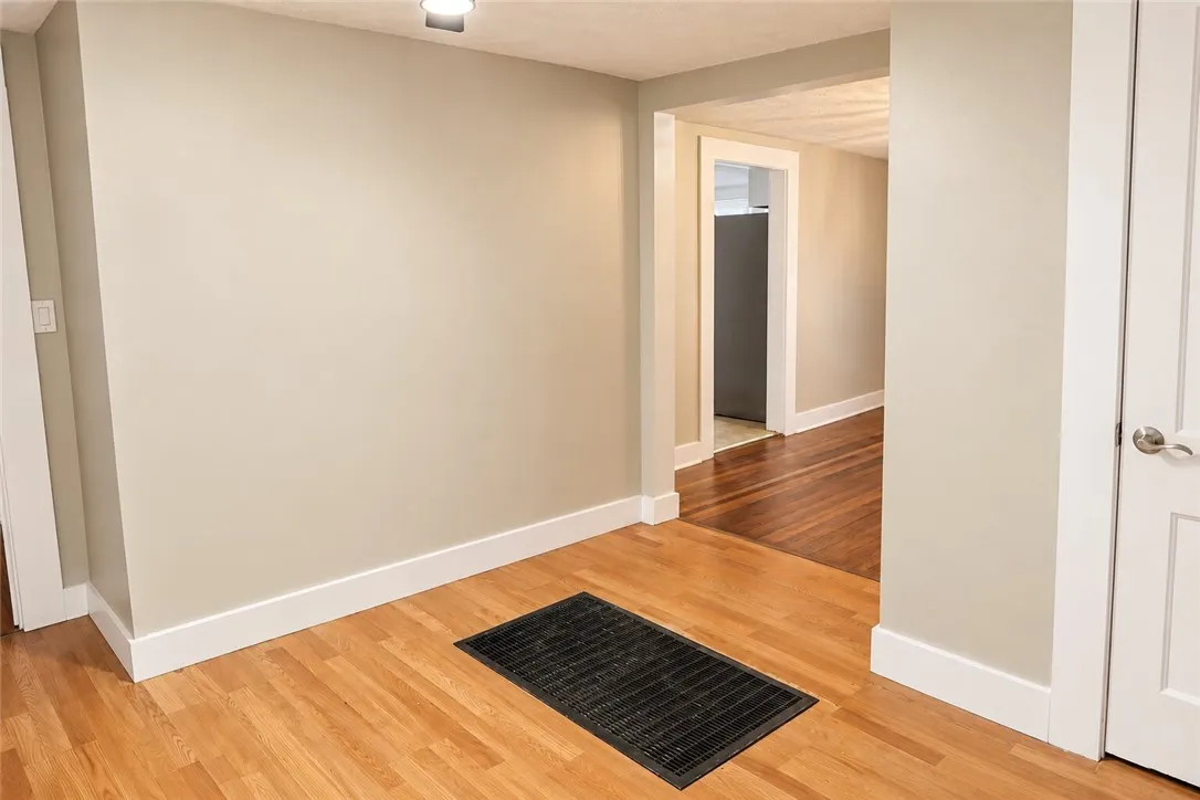 Gleaming hardwood floors and crisp white trim connect the welcoming entryway to adjacent living spaces.
