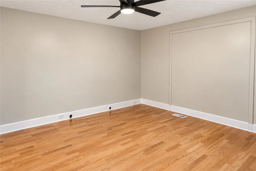 Warm hardwood flooring and detailed baseboards anchor this versatile interior space.