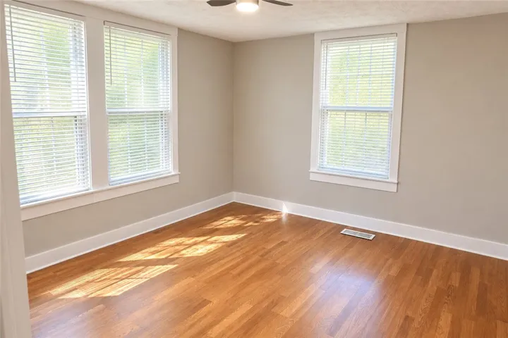 Rich hardwood flooring complements the classic white trim and abundant natural light in this room.