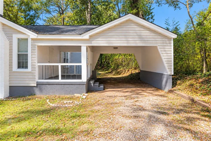 A convenient carport is situated alongside a covered side porch with a secure private entrance.