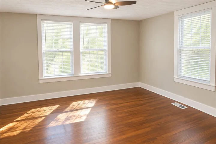 Rich wood flooring pairs beautifully with classic white trim in this versatile living space.