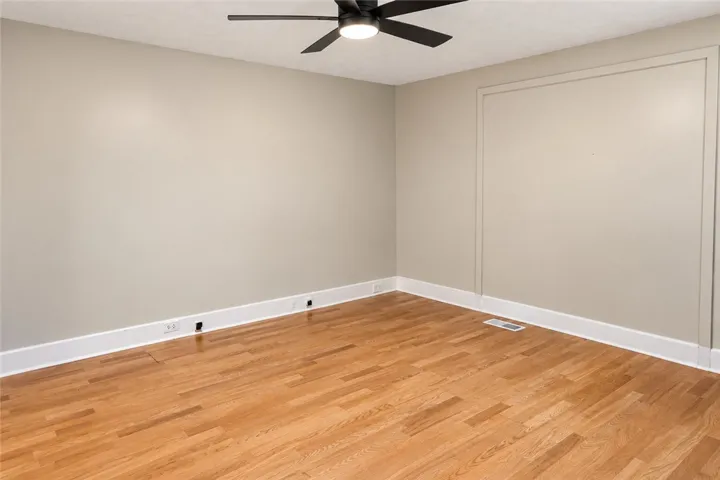 Warm hardwood flooring and detailed baseboards anchor this versatile interior space.