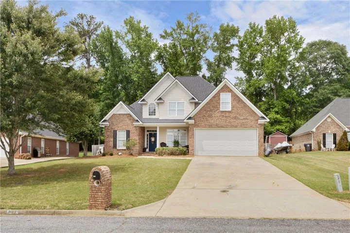 An inviting exterior features a brick and siding facade with a manicured lawn.