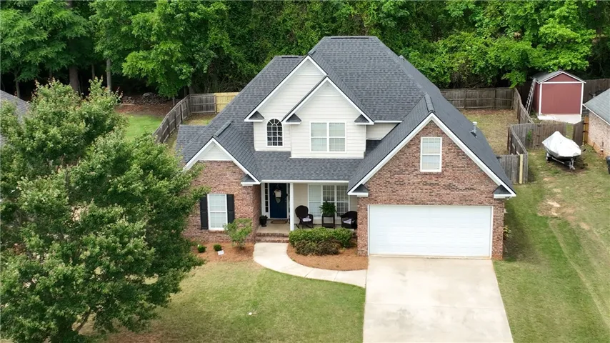 An inviting brick facade and paved driveway characterize this multi-level home with a private backyard.