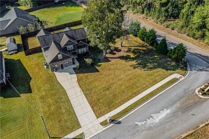 A long concrete driveway leads up to this brick and siding corner-lot home.