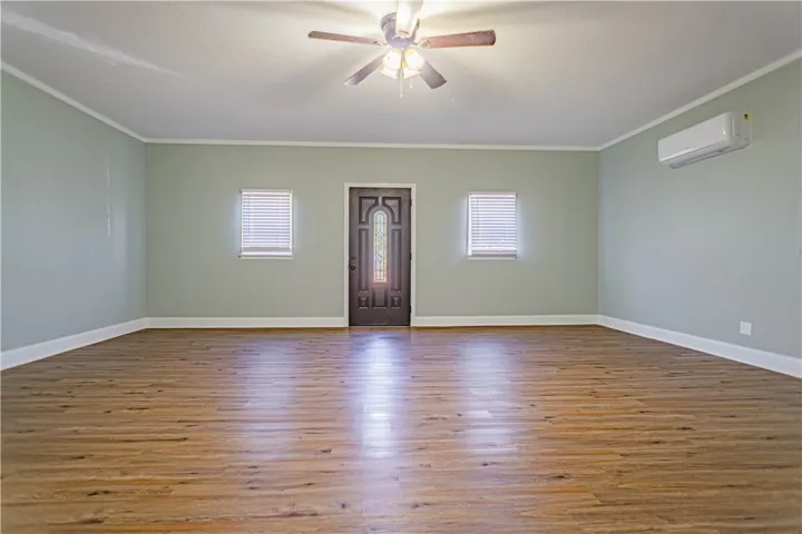 Rich wood-look flooring sets an inviting tone in this versatile living space.
