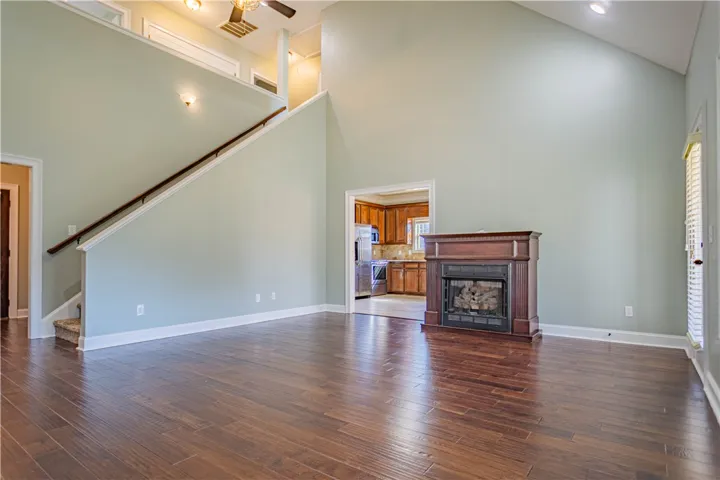 Dramatic vaulted ceilings and rich wood floors anchor this grand living area with fireplace.